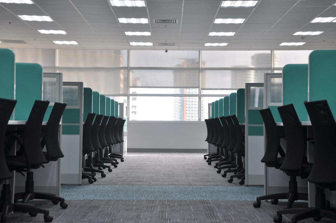 empty-black-rolling-chairs-at-cubicles-2zzp12chxhu